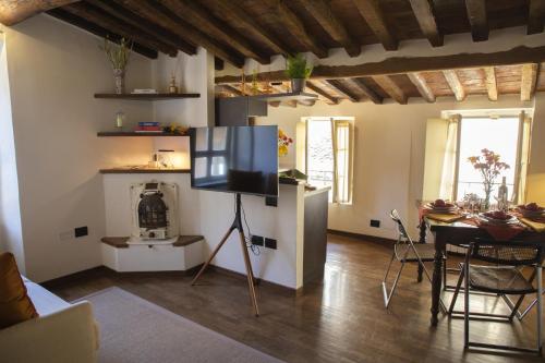 un soggiorno con TV su supporto in una stanza di La Mansardina Beccheria Central Apartment 1 double bedroom, 1 sofa bed a Lucca