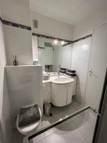 a white bathroom with a sink and a toilet at Studio Residence Du Casino in Menton