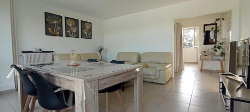 un salon avec une table et des chaises dans l'établissement Le Belle vue, à Saint-Étienne