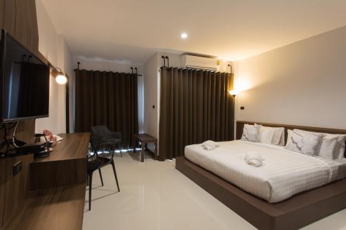 um quarto de hotel com uma cama e uma secretária em Well Timed Hotel em Cidade de Krabi