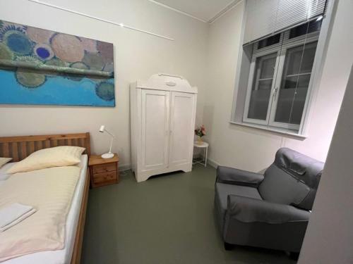 1 dormitorio con 1 cama y 1 silla en Ferien Mittendrin - Ferienwohnung 9, en Schwerin