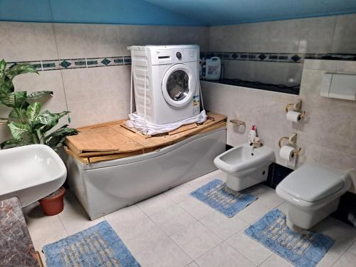 a bathroom with a washing machine on top of a tub at B&B LA SPINA 2 in Poggiridenti