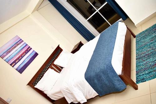 1 dormitorio con 1 cama con sábanas blancas en 9 degrees apartments, en Nairobi