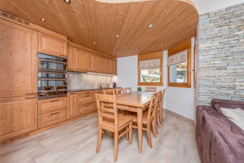 a kitchen with a wooden table and chairs at Bellathos in Leukerbad