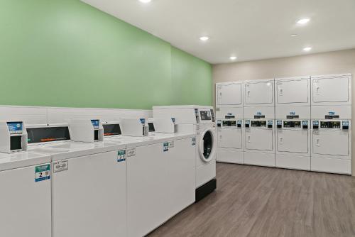 a laundry room with white washers and machines at WoodSpring Suites Fort Myers - Cape Coral in Fort Myers