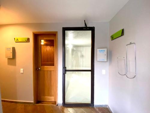 a bathroom with a glass door in a room at Suite Presidencial en hotel próximo al aeropuerto in Rionegro