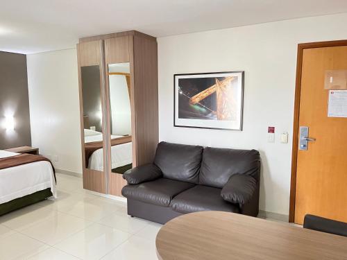 sala de estar con sofá y cama en Flat 2313 - Crystal Place, en Goiânia