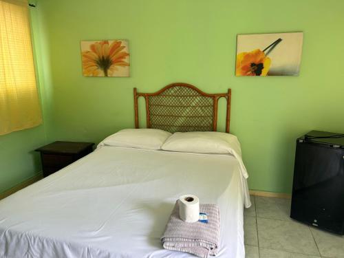 a bedroom with a bed with a roll of toilet paper on it at Coco Hotel and Hostel in Sosúa
