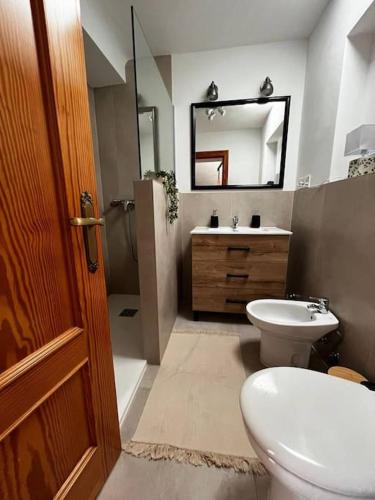 a bathroom with a toilet and a sink and a mirror at Casa de 5 habitaciones hasta 9 plazas, La Casilla en Dúrcal, Granada in Dúrcal