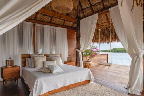 a bedroom with a bed and a view of the water at Villa with salt pool Aruba in Savaneta