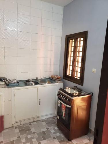 a kitchen with a sink and a stove at Villa ECOGIB in Ouagadougou