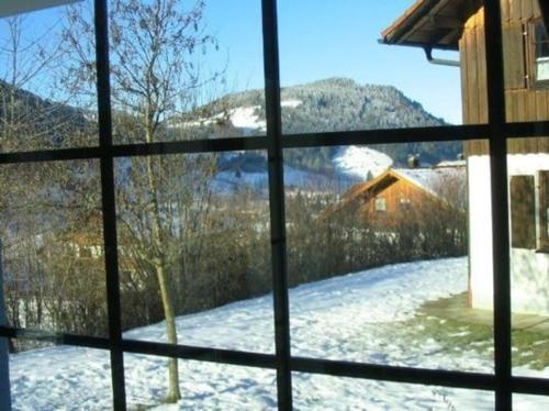 desde una ventana de un patio cubierto de nieve en Ferienhaus Alpkönig in Missen mit Garten und Terrasse, en Missen-Wilhams