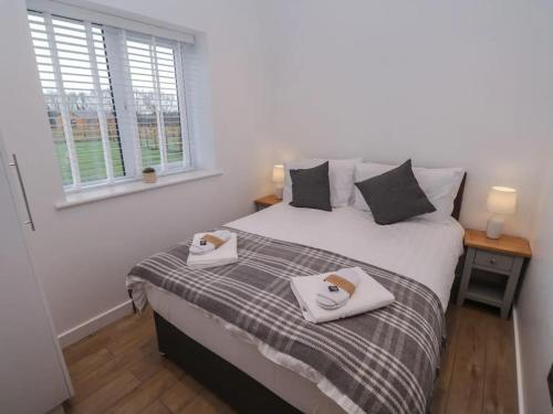 a bedroom with a bed with two towels on it at Oak Lodge in Ashbourne