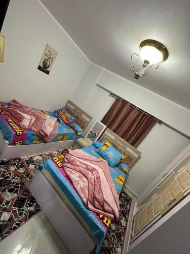 a small bedroom with two beds and a light at شاليهات اهرامات بورتو السخنة in Ain Sokhna