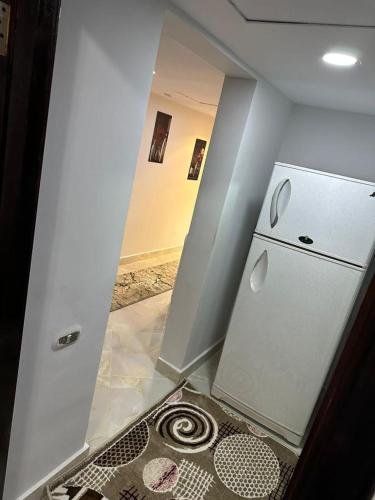 a kitchen with a white refrigerator in a room at شاليهات اهرامات بورتو السخنة in Ain Sokhna