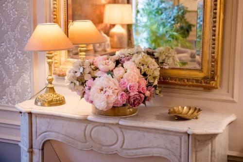 un vase de fleurs sur une table avec deux lampes dans l'établissement Elegant luxury private apartment by Eiffel Tower, à Paris