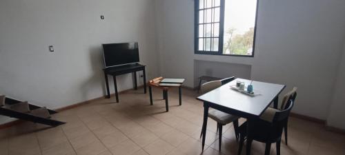 a room with a room with a table and a television at La Via Apart in Bahía Blanca