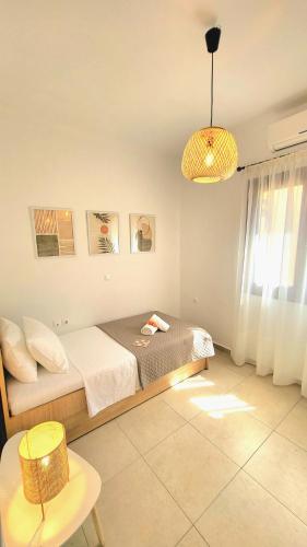 a bedroom with a bed and a pendant light at Gardenia - Morfi Village with pool in Exopoli