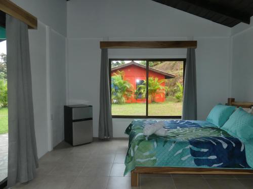 een slaapkamer met een bed en een groot raam bij Villa El Tucán in Bijagua