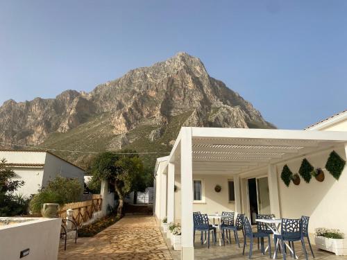 a house with a table and chairs in front of a mountain at B&B Sicilia in Versi in Custonaci