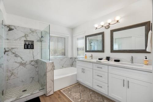 a white bathroom with a shower and a tub and a sink at Saguaro Family Fiesta in Mesa