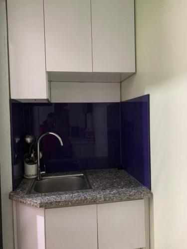 a kitchen with a sink and white cabinets at Mio Hotel in Hải Dương