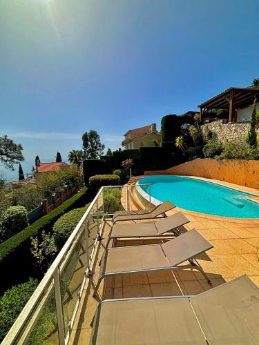 - un groupe de chaises longues à côté de la piscine dans l'établissement Villa Provençale vue mer & piscine privée, à Saint-Raphaël