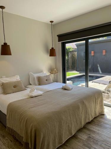 a bedroom with a large bed and a large window at Villa Oasis - w pool near Cascais centre in Cascais