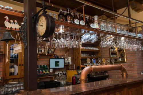 a bar with glasses and a clock on the wall at Penzión ROYAL in Bytča