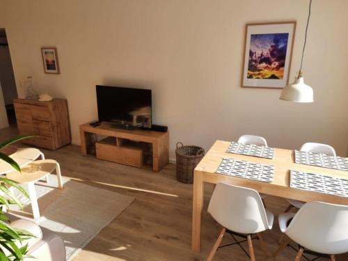 salon ze stołem, krzesłami i telewizorem w obiekcie FeWo Steuerbord w mieście Malente