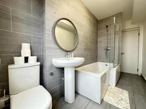 a bathroom with a sink and a toilet and a mirror at Two Bedroom Apartment Near Park Lane in London