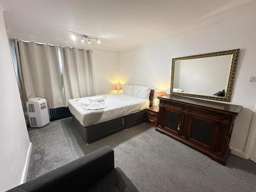 a bedroom with a bed and a mirror on a dresser at Two Bedroom Apartment Near Park Lane in London