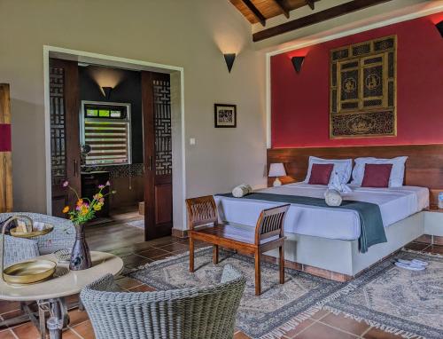 a bedroom with a large bed and a table and chairs at Gal Oya Lake Club 