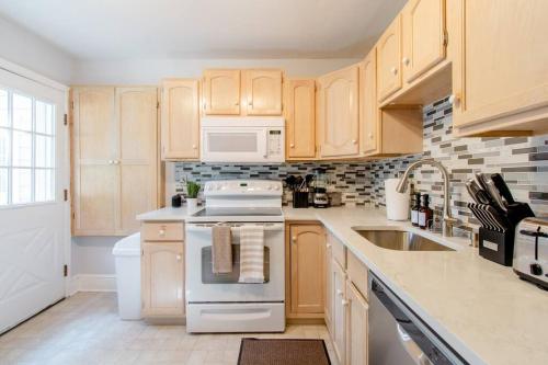 a kitchen with white appliances and wooden cabinets at Princeton Gem - Walk Everywhere! in Princeton