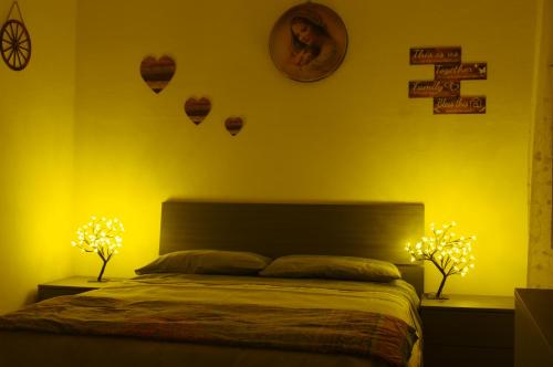 Gianni's beautiful house in the mountains في Lama dei Peligni: غرفة نوم مع سرير مع مصباحين وقلوب على الحائط