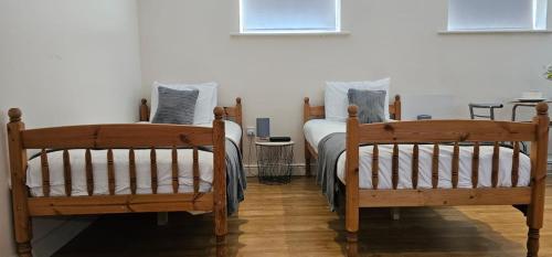 two wooden beds in a room with aermottermott at Modern Studio apartment in Town center in Ipswich