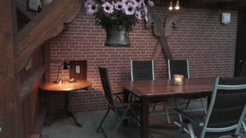 a dining room with a table and chairs and a brick wall at Ferienhaus mit überdachter Terrasse und Carport in Walsrode