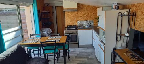 une petite cuisine avec une table et un réfrigérateur dans l'établissement Studio location saisonnière bord de mer., à Saint-Michel-Chef-Chef