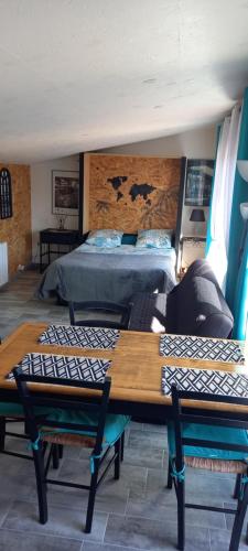 une chambre avec un lit, une table et des chaises dans l'établissement Studio location saisonnière bord de mer., à Saint-Michel-Chef-Chef