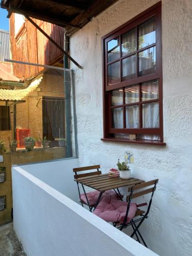 a table and two chairs on a patio with a window at J3M Houses in Porto