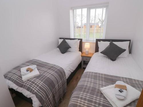 two twin beds in a room with a window at Elm Lodge in Ashbourne