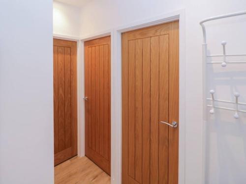 a bathroom with two wooden doors and a walk in shower at Elm Lodge in Ashbourne