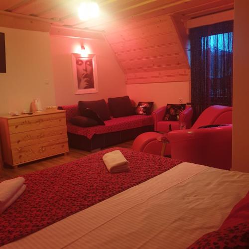 1 dormitorio con 1 cama y sala de estar con muebles de color rojo. en LOV APARTAMENT, en Kościelisko