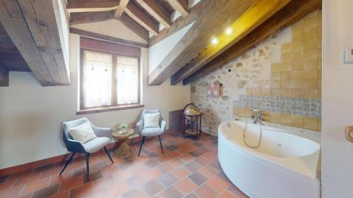 a bathroom with a tub and two chairs and a table at Casa Rural La Fuente del Junco in Caballar