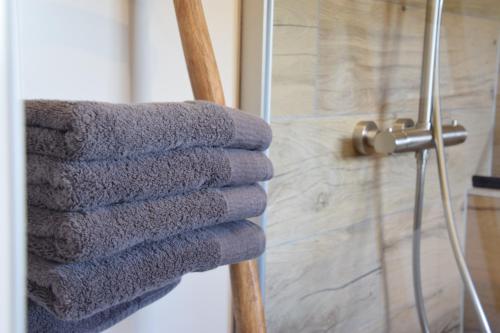 uma pilha de toalhas num toalheiro na casa de banho em It Foarhús em Eernewoude