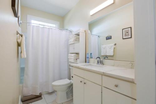 a white bathroom with a toilet and a sink at Backyard Beauty Bungalow in Jackson in Jackson