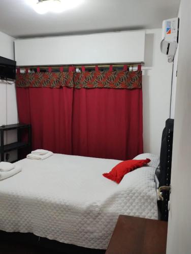 um quarto com uma cama com uma cortina vermelha em Departamento Blanca em Mendoza