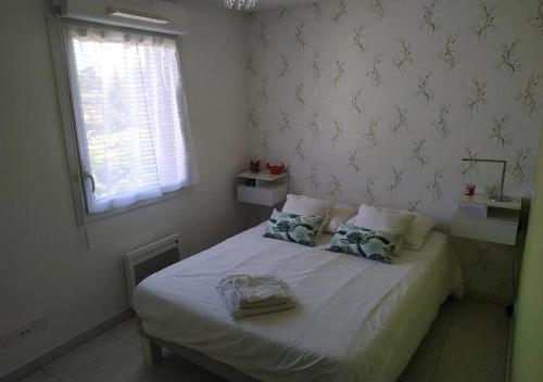 - une chambre avec un lit avec deux oreillers et une fenêtre dans l'établissement Magnifique rooftop duplex climatisé aux ARCEAUX, à Montpellier