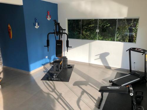 a room with a gym with two treadmills and a window at Casa na Praia de Santiago, próxima a Maresias! in São Sebastião