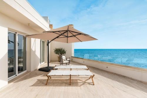 une terrasse avec une table et un parasol dans l'établissement Ferienhaus für 6 Personen ca 100 qm in Cicirata, Sizilien Ostküste von Sizilien, à Avola
